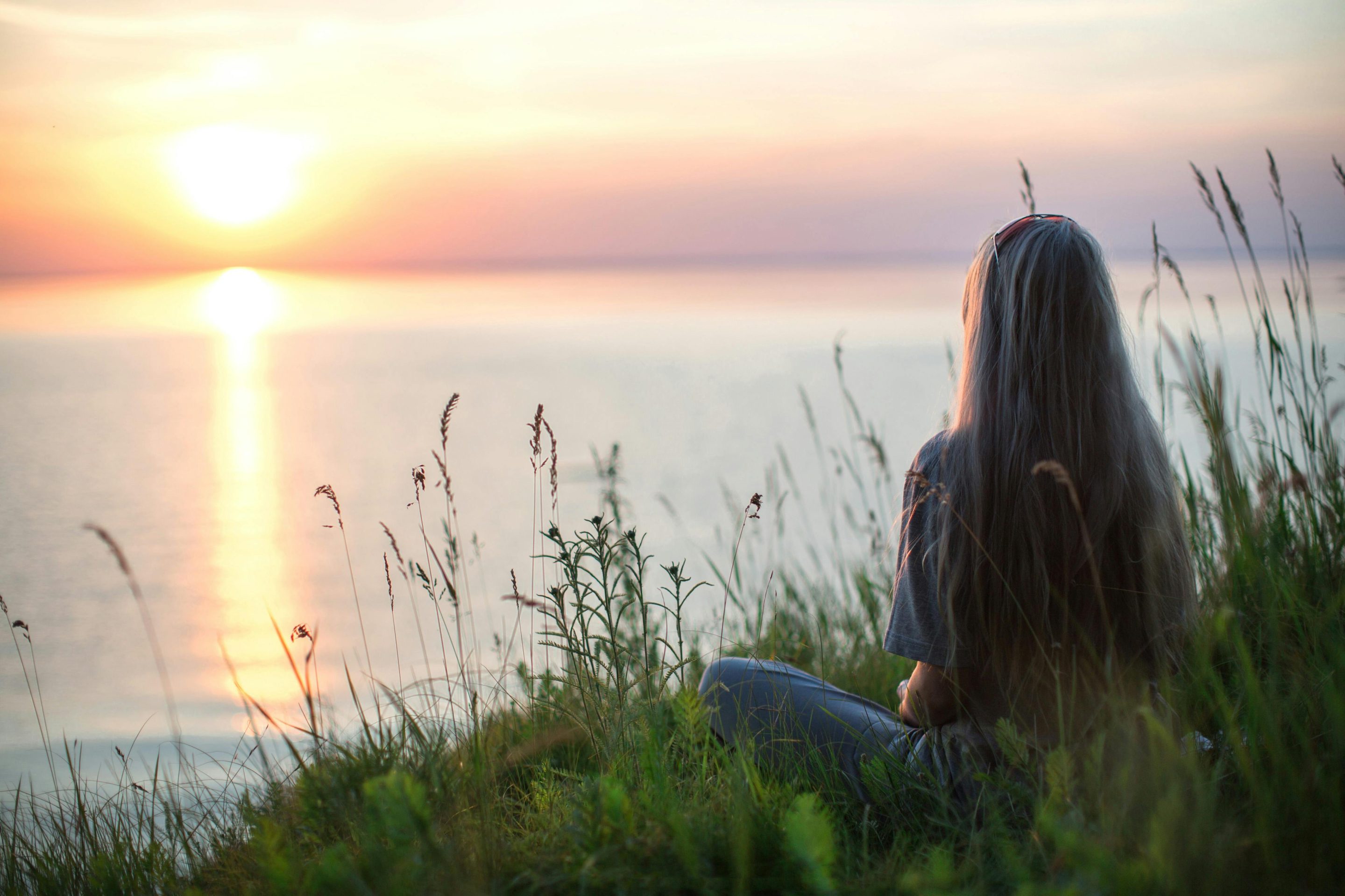Woman looking at a sunset over the water